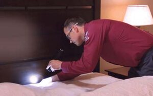 Batzner pest control technician inspecting bed for bed bugs in WI home