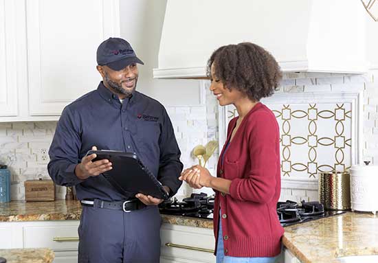 Batzner pest control technician speaking with client within a home in Wisconsin.