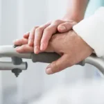 Nurse's hand supporting patient's on a walker | Batzner Pest Control serving Wisconsin