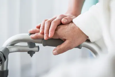 Nurse's hand supporting patient's on a walker | Batzner Pest Control serving Wisconsin