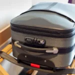 Luggage sitting on a luggage rack in a hotel room.