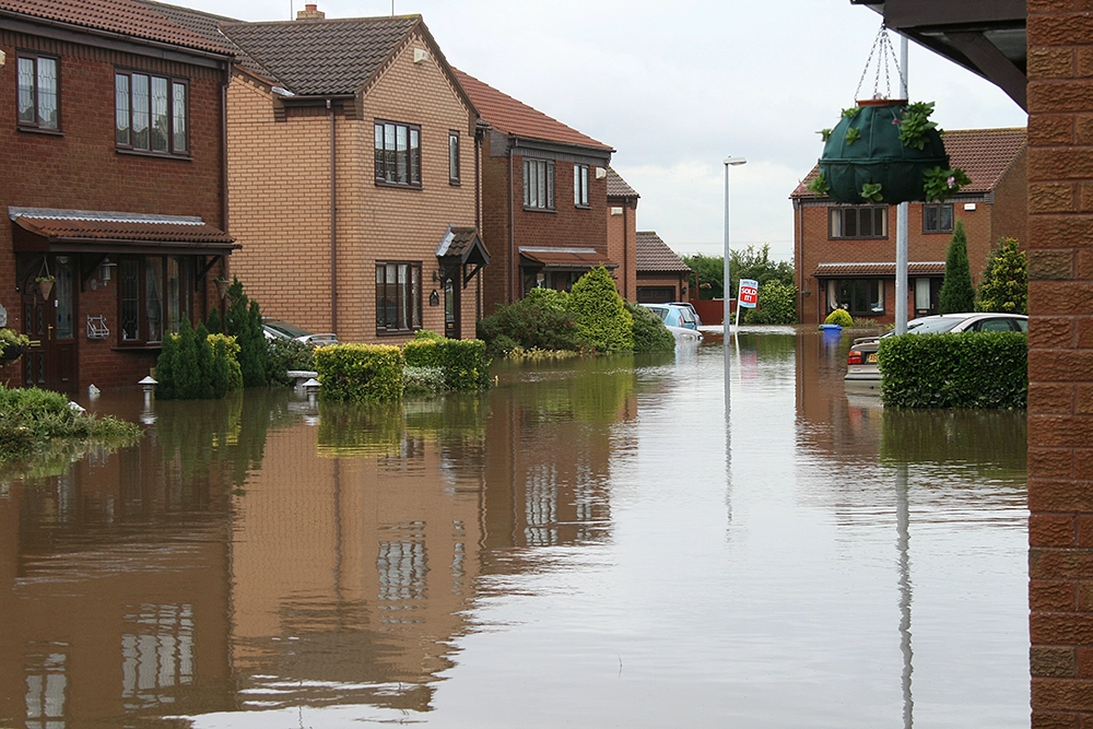 A residential neighborhood street flooded with high waters.