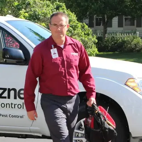 A Batzner Pest Control technician walking with tool bag to a Wisconsin residence before a pest inspection