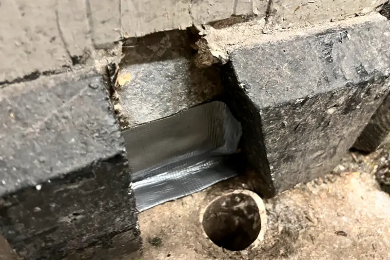 Flexi Armour sealing the crack between bricks wall & concrete flooring, used by Batzner Pest Control technicians to protect against pests.