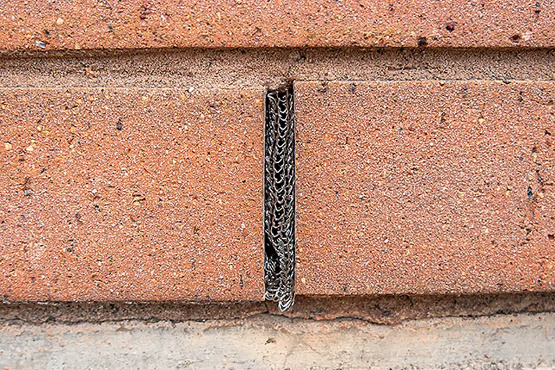 Flexi Armour covering the weep hole gap space between bricks, used by Batzner Pest Control technicians to protect against pests.