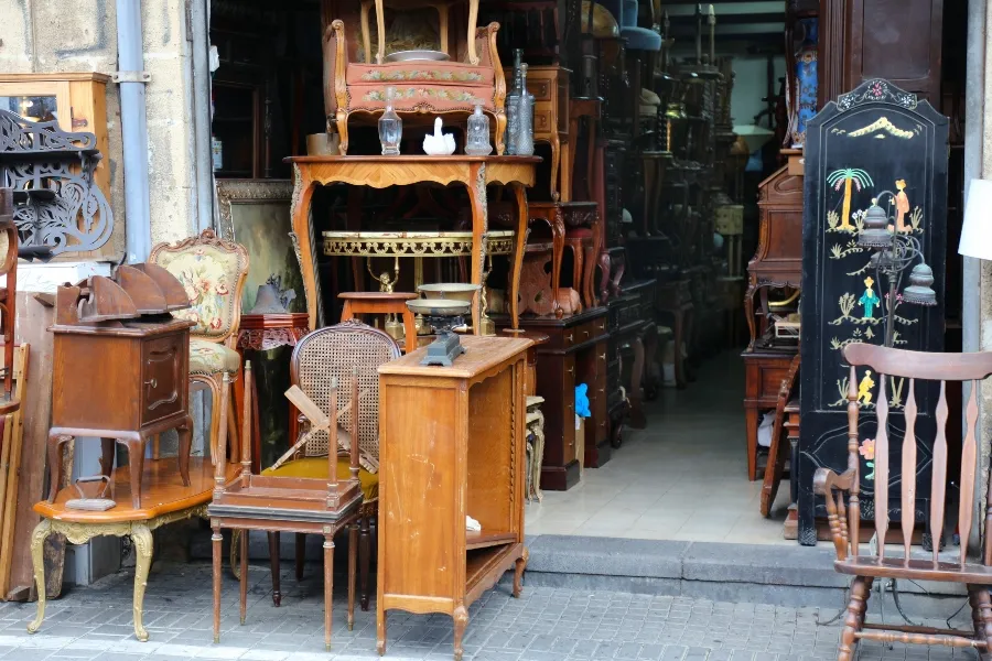 An antique store filled with used wooden furniture, chairs, and tables.